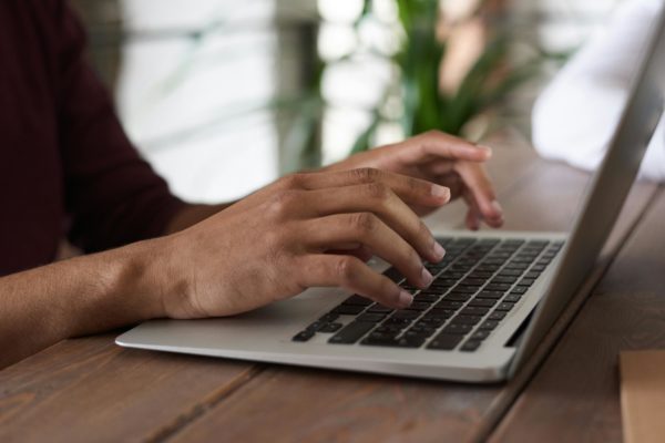 mains qui tapent sur clavier d'un ordinateur portable